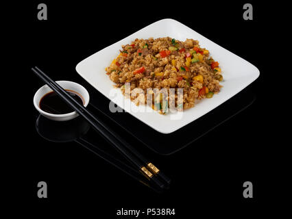 Piatto vietnamita Com Rang è riso fritto solitamente miscelati con altri ingredienti come uova, verdure, piatti di pesce o di carne. Isolato su nero. Servita con Foto Stock