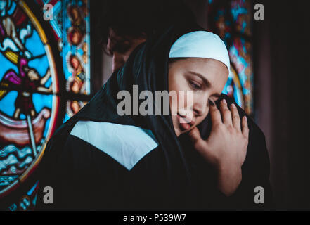 Nun e sacerdote pregare e trascorrere il tempo nel monastero Foto Stock