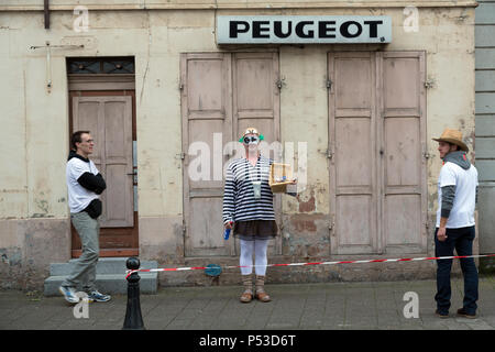 Francia - Scene di strada con uomo dissimulata e Peugeot scritte Foto Stock