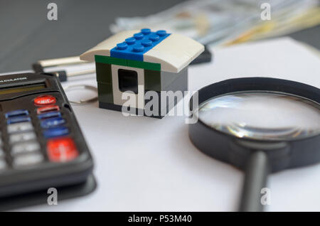 Il concetto di prestito di alloggiamento. Soldi, calcolatrice, toy house Foto Stock