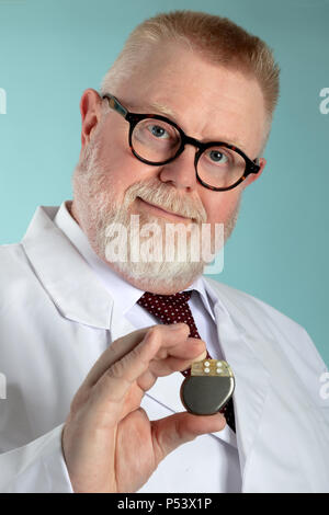 Medico maschio Pacemaker di contenimento nella parte anteriore della fotocamera con sfondo blu Foto Stock