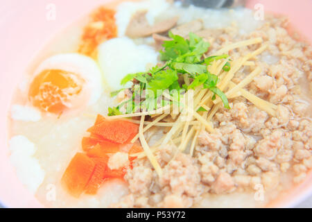 La carne di maiale congee con uovo Foto Stock