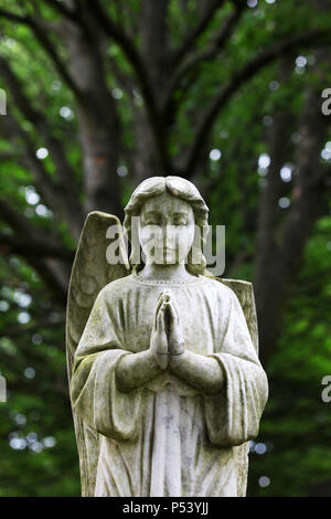 Una statua di un angelo orante con un parafango rotto in seduta i motivi di saughton cimitero in Edinburgh Foto Stock