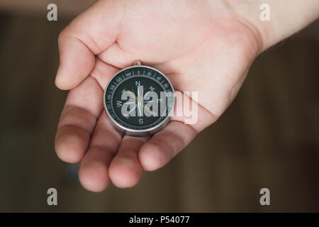 Giovane uomo detiene una bussola in mano Foto Stock