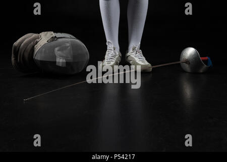 Ritratto di donna che indossa bianco costume di scherma la pratica con la spada. Foto Stock