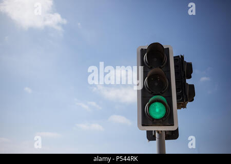 Il semaforo verde. Segnale che è sicuro di andare sulla strada. Blu cielo con poche nuvole sfondo. Chiudere fino sotto Visualizza spazio per il testo. Foto Stock