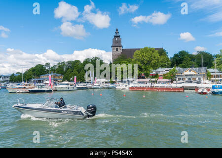 NAANTALI, Finlandia - 23/6/2018: una piccola barca di guida mediante il Naantali chiesa in Naantali Marina Foto Stock