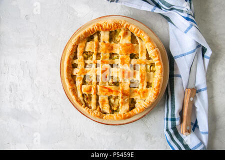 In casa giovani torta cavolo dalla pasta sfoglia servita su una piastra. Pietra Bianca dello sfondo. Foto Stock