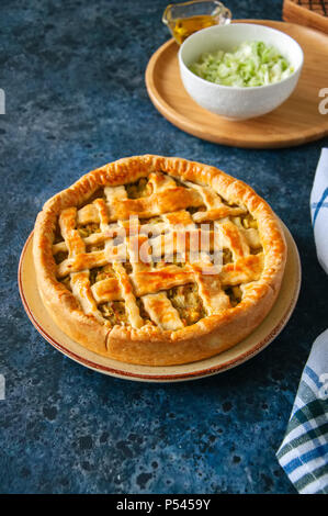 In casa giovani torta cavolo dalla pasta sfoglia servita su una piastra. La pietra blu sullo sfondo. Foto Stock