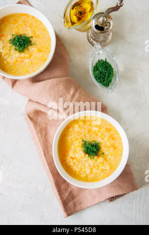 Lenticchia e zuppa di bulgur purea in una ciotola bianco su una pietra bianca ba Foto Stock