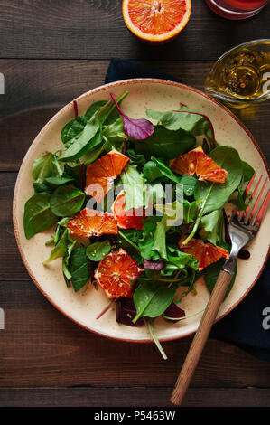 Insalata fresca mescolare con arance sanguigne su un sfondo di legno. Mangiare sano concetto. Foto Stock
