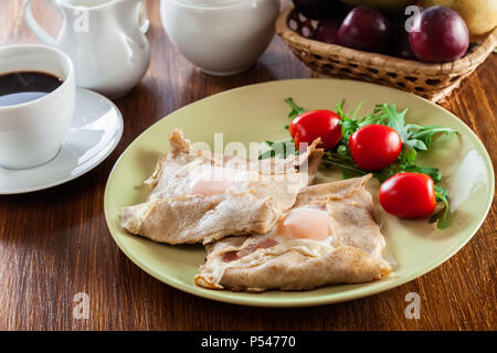 Galette completa. Crepes con prosciutto e formaggio e uovo in camicia su una piastra. Cucina francese Foto Stock