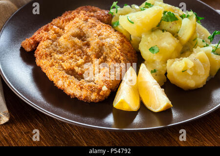 In casa impanati schnitzel viennesi con insalata di patate su una piastra Foto Stock