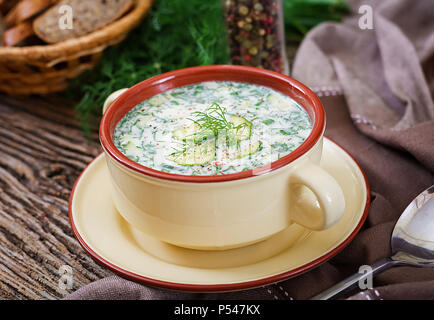 Estate yogurt zuppa fredda con uova, cetrioli, e aneto sul tavolo di legno. Okroshka. Il cibo russo Foto Stock