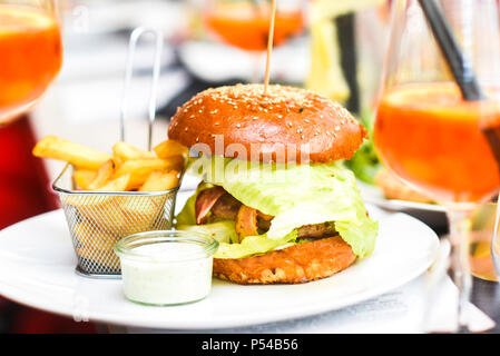 Hamburger con patatine fritte su di una piastra in un ben servita al ristorante. Foto Stock