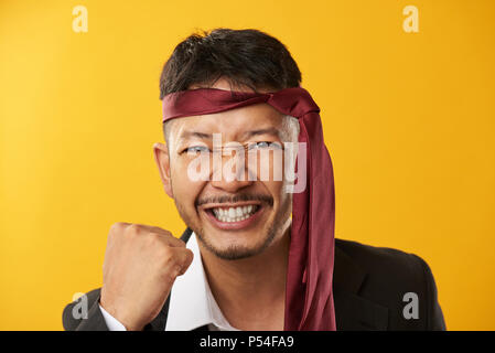 Ritratto di felice asian giovane uomo isolato su sfondo giallo Foto Stock