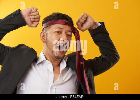 Asian lavoratore di ufficio a sbadigliare dopo una lunga giornata di lavoro Foto Stock