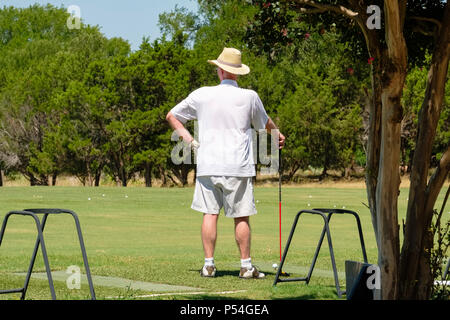 Golfista maschile senior che guarda al fondo su un campo da golf Sun City Texas adulto pensione comunità driving range Foto Stock