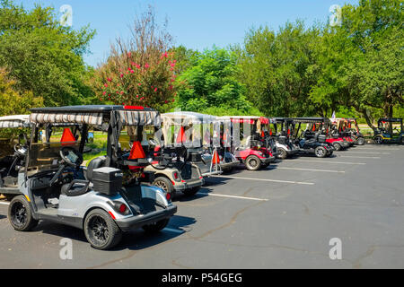 Golf cart elettrico alimentato a batteria attendono i golfisti nel parcheggio del campo da golf della comunità di anziani di Sun City Texas Foto Stock