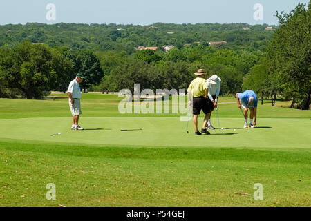 4 uomini anziani che si godono una partita di golf su un campo da golf della comunità di pensione per adulti di Sun City Texas Foto Stock