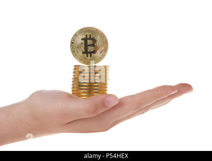 Digital Cryptocurrency valuta. Golden bitcoin coin impilati sul bilanciamento del giovane femmina mano caucasica e isolato su sfondo bianco. Bit di fisica c Foto Stock