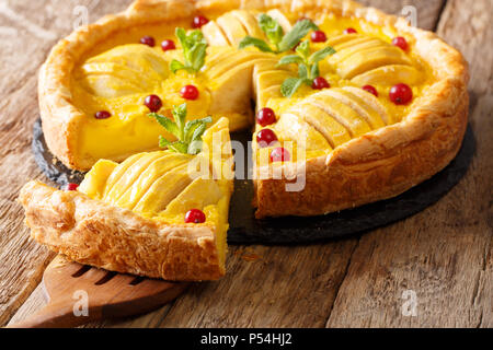 Tagliate a fette di mirtillo palustre di apple pie con crema pasticcera vicino sul tavolo orizzontale. Foto Stock