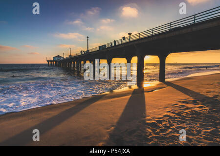 Colorato Cielo e nubi su Manhattan Beach Pier al tramonto con lunghe ombre sulla spiaggia, Manhattan Beach, California Foto Stock