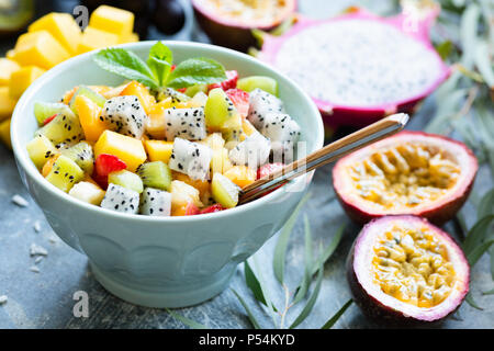 Macedonia di frutta con Esotici frutti tropicali nel recipiente. Mangiare sano, uno stile di vita sano concetto Foto Stock