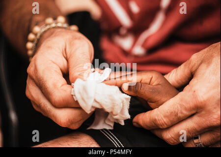 Mali, Africa - circa agosto 2009 - uomo maturo holding e nero di lavaggio mani del bambino nel villaggio rurale al di fuori di Bamako Foto Stock