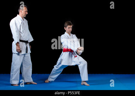 Maschio di istruttore di karate formazione bambini nel dojo Foto Stock