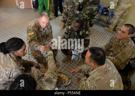 Gli avieri e i membri delle forze Armées Nigeriennes condividere il cibo e la conversazione a Nigerien Air Base 201, Niger, 10 maggio 2017. Il pranzo viene trattenuto mensilmente, posizioni di negoziazione tra la ventola e il 724th EABS, per condividere le preoccupazioni e costruire partnership. Foto Stock