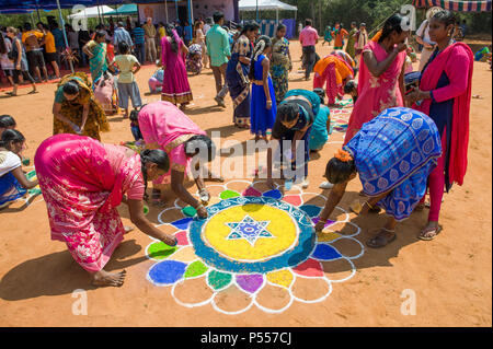 AUROVILLE, INDIA - 4 marzo 2018: Sangamam Festival. Donne che disegnano un kolam Foto Stock