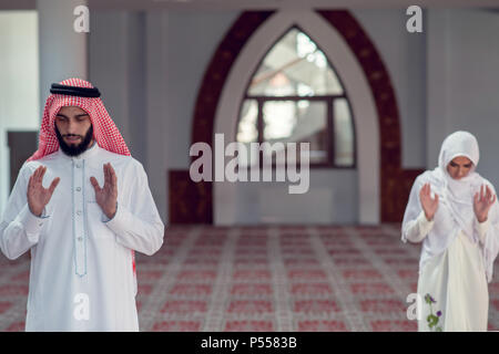 Musulmani l uomo e la donna che prega per Allah nella moschea insieme Foto Stock