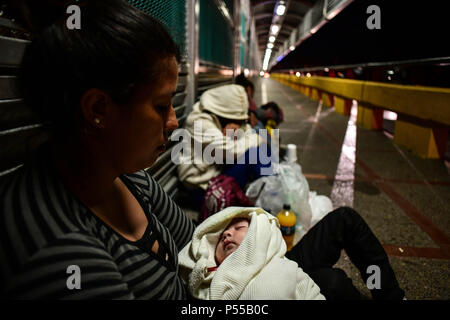 Brownsville, Texas, Stati Uniti d'America. Il 24 giugno 2018. Cristina, 27, una donna honduregne, i suoi due mese baby Naomi e todler Manuel, arrivano la domenica notte al ponte di collegamento Matamoros, Messico a Brownsville, Texas, l'ultima parte di un percorso iniziato due mesi fa a San Pedro Sula in Honduras. Come Trump administration codificati per affrontare una crisi di immigrazione sul confine, un continuo flusso di migranti sono in arrivo ogni giorno. Credito: Miguel Juarez Lugo/ZUMA filo/Alamy Live News Foto Stock