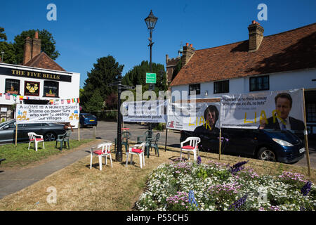 Harmondsworth, UK. Il 25 giugno 2018. Bandiere contro Heathrow espansione, compreso uno lodando ex ministro Greg mani per le sue dimissioni, nel verde nel cuore di Harmondsworth village. Gran parte del centro storico di Harmondsworth villaggio sarebbe distrutta dovrebbe una terza pista sarà costruita presso l'aeroporto di Heathrow. MPs votazione alla Camera dei comuni questa sera su se o non approvare Heathrow espansione. Credito: Mark Kerrison/Alamy Live News Foto Stock