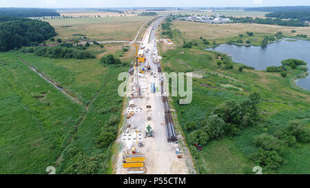 19 giugno 2018, Germania, Tribsees: una joint venture da parte di due grandi imprese di costruzioni a lavorare sul fondamento di un ponte di fortuna presso il cantiere per la costruzione della A20 autostrada Autobahn (antenna shot con un drone). Il totale dei costi per la costruzione del ponte di fortuna ammontano ad un totale di 51,3 milioni di euro secondo il ministro dei Trasporti Pegel, di cui 31 milioni di euro sono stati stanziati per le opere di fondazione. Un totale di 232 pilons - con un diametro di 1,2 metri ed una lunghezza media di 24 metri - sono necessari per la costruzione. Un vicino a 100 metri di lungo tratto dell'A20 è affondato in paludoso gr Foto Stock