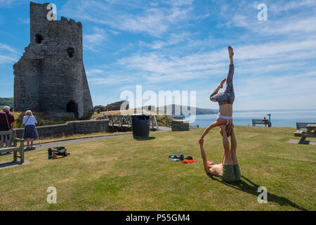 Aberystwyth, Galles. 25 GIU, 2018. Regno Unito: Meteo Meteo REGNO UNITO: molto adatta coppia giovane pratica loro Acro Yoga ( un mix di acrtobatics e yoga) vicino al castello in Aberystwyth, su un altro ancora scintillante la giornata di caldo sole ininterrotta. Il Regno Unito è il titolo in un mini ondata di caldo con temperature meteo per colpire 29º o 30º Celsius entro la metà della settimana foto © Keith Morris / Alamy Live News Foto Stock