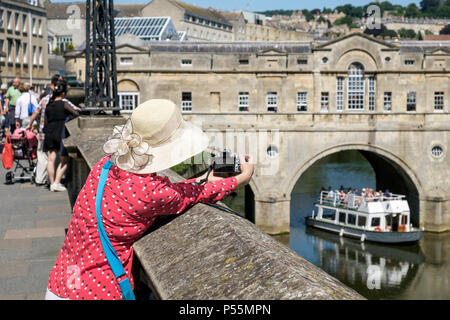 Bath, Regno Unito, 25 Giugno, 2018. Come bagno gode di un altro e calda giornata di sole una donna è raffigurato scattare una fotografia di un tour in barca come passa sotto il ponte Pulteney, forecasters prevedono che il clima caldo proseguirà anche nella prossima settimana. Credito: lynchpics/Alamy Live News Foto Stock