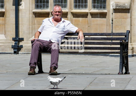 Bath, Regno Unito, 25 Giugno, 2018. Come bagno gode di un altro sole e caldo giorno un uomo è raffigurato seduto al sole di fronte all'Abbazia di Bath, forecasters prevedono che il clima caldo proseguirà anche nella prossima settimana. Credito: lynchpics/Alamy Live News Foto Stock