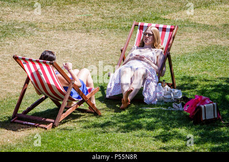 Bath, Regno Unito, 25 Giugno, 2018. Come bagno gode di un altro e calda giornata di sole due donne seduti nella vasca da bagno's Parade Gardens sono illustrati sfruttando il bel tempo e il sole caldo, forecasters prevedono che il clima caldo proseguirà anche nella prossima settimana. Credito: lynchpics/Alamy Live News Foto Stock