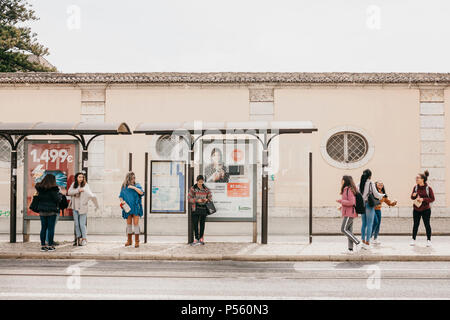 Lisbona, 18 Giugno 2018: i giovani alla fermata in attesa di trasporto. Ordinario della vita della città Foto Stock