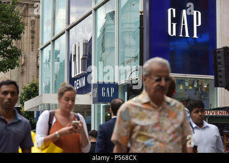 Gli amanti dello shopping, per i turisti e per chi lavora in ufficio a piedi passato il flagship store Gap su Oxford Street nel centro di Londra Foto Stock