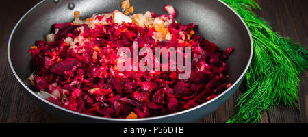 Carote, barbabietole e cipolle in una padella, intorno all aneto, su di un legno marrone dello sfondo. Ingredienti per borsch Foto Stock