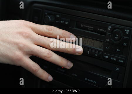 Mano umana cambiare la stazione radio. Foto Stock