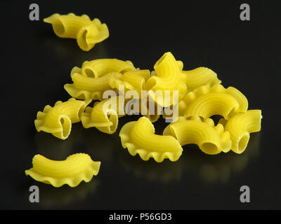 Giallo crudo La pasta italiana Le creste di gallo su sfondo scuro close-up Foto Stock