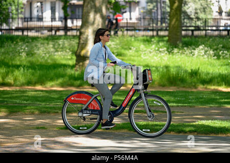 Giovane donna con possibilità di noleggio bici nel parco, Hyde Park, London, Regno Unito Foto Stock