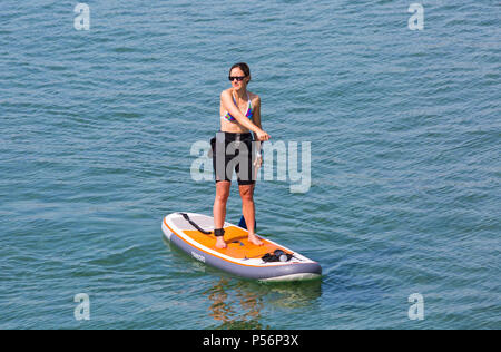 Paddleboarder, donna paddleboarding, a Bournemouth Dorset, Regno Unito nelle calde giornate di sole nel giugno - paddle boarder paddle boarding Foto Stock