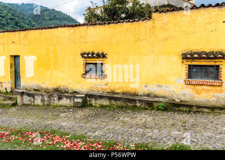 San Juan del Obispo, Guatemala - Giugno 25, 2017: dipinto di giallo house & processione tappeto per Borgo Santo patrono giorno vicino a Colonial Antigua. Foto Stock