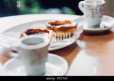 Tradizionale pasticceria portoghese chiamato pastel de nata e caffè Foto Stock