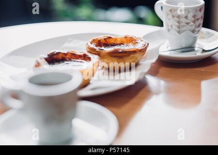 Tradizionale pasticceria portoghese chiamato pastel de nata e caffè Foto Stock